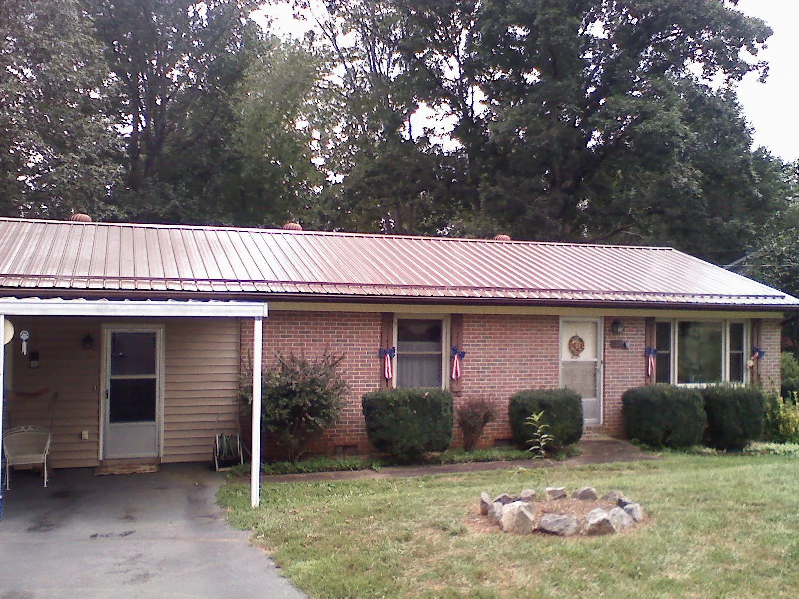 Bronze metal roof and carport on a brick ranch home — Roof Repair work by our crew in Riverdale